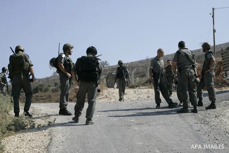 Israeli soldiers stand guards after the clashes between Palestinians and Jewish settlements close to the northern West Bank village of Burin on July 26, 2010, which began when Israeli troops removed two mobile homes set...