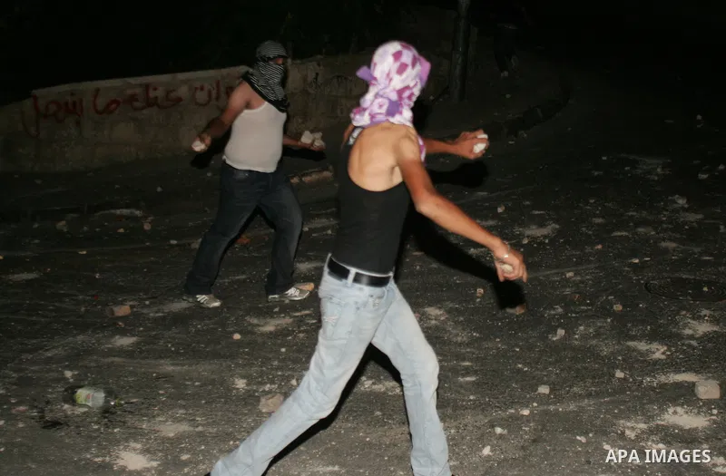 Palestinian youths ready to throw stones at Israeli police during clashes in the Arab east Jerusalem neighbourhood of Silwan, on July 27, 2010, as some 200 Palestinian youths clashed in a part of occupied east Jerusalem...