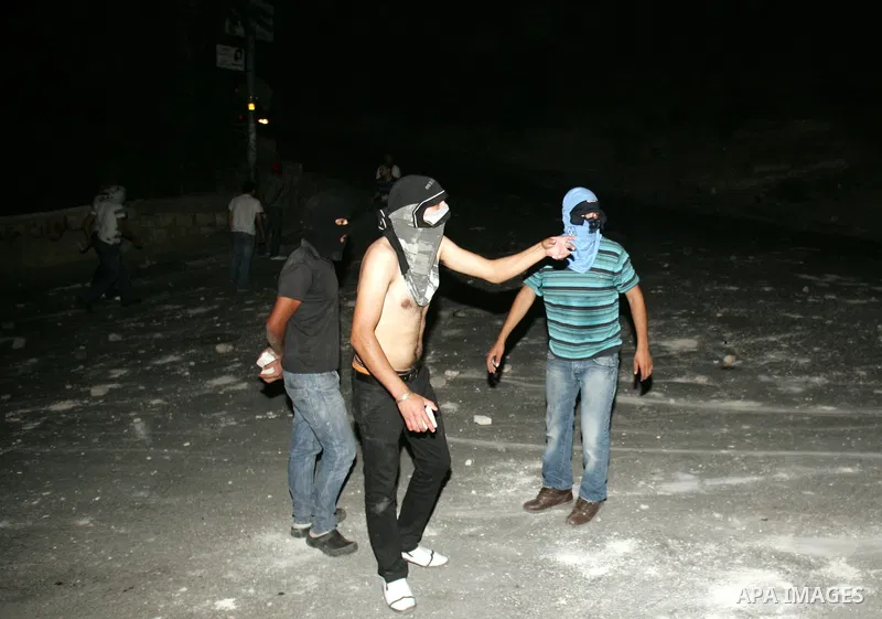 Palestinian youths ready to throw stones at Israeli police during clashes in the Arab east Jerusalem neighbourhood of Silwan, on July 27, 2010, as some 200 Palestinian youths clashed in a part of occupied east Jerusalem...