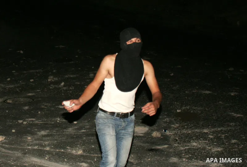 Palestinian youths ready to throw stones at Israeli police during clashes in the Arab east Jerusalem neighbourhood of Silwan, on July 27, 2010, as some 200 Palestinian youths clashed in a part of occupied east Jerusalem...