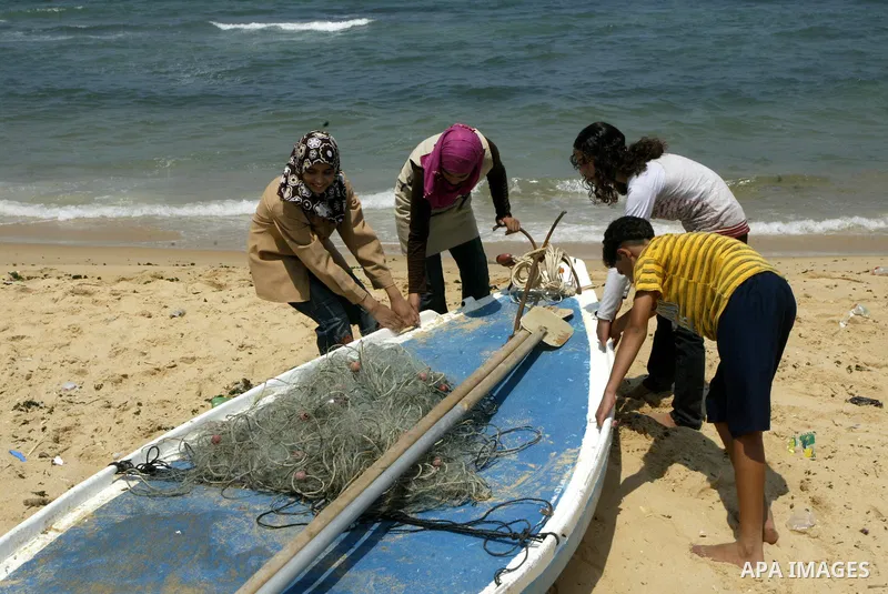 Madlin, her brother Kayed and sister Reem , take their small boat to fish off the coast of Gaza City on July 25, 2010. Madlin is the first girl in the Gaza Strip to fish professionally in order to support her poor family...