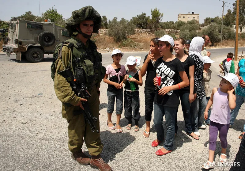 Palestinian, Israeli and international activists take part in a demonstration against the expansion of the nearby Jewish settlement of Halamish in the West Bank village of Nabi Saleh near Ramallah , Friday, July 30, 2010...