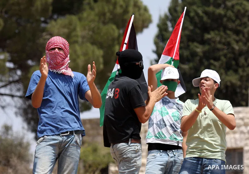 Palestinian, Israeli and international activists take part in a demonstration against the expansion of the nearby Jewish settlement of Halamish in the West Bank village of Nabi Saleh near Ramallah , Friday, July 30, 2010...