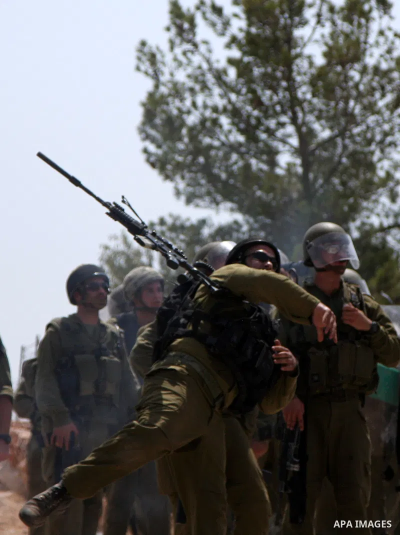 Israeli soldiers fire tear gas canisters at demonstrators during a protest against Israel's separation barrier in the West Bank village of Bilin near Ramallah, Friday, July 30, 2010. Photo by Wagdi Eshtayah