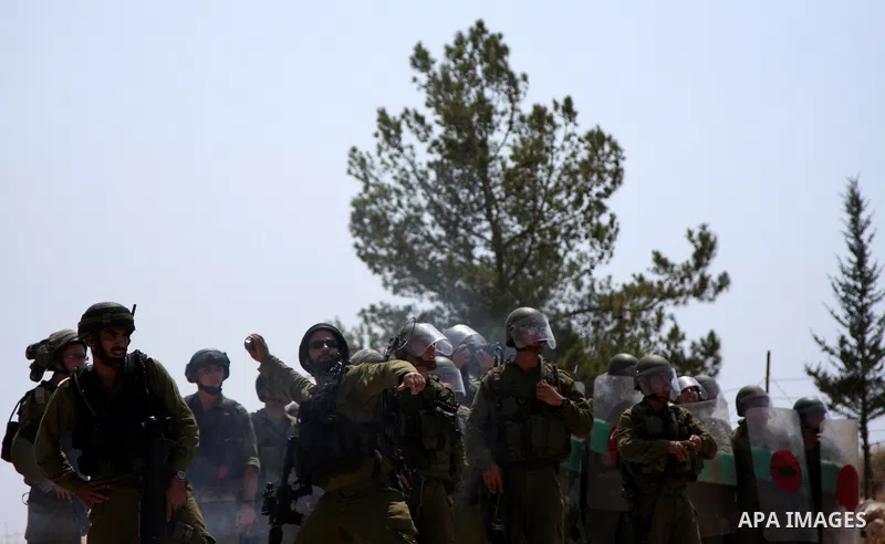 Israeli soldiers fire tear gas canisters at demonstrators during a protest against Israel's separation barrier in the West Bank village of Bilin near Ramallah, Friday, July 30, 2010. Photo by Wagdi Eshtayah