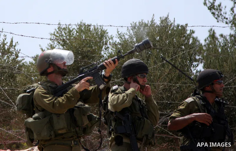 Israeli soldiers fire tear gas canisters at demonstrators during a protest against Israel's separation barrier in the West Bank village of Bilin near Ramallah, Friday, July 30, 2010. Photo by Wagdi Eshtayah