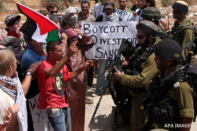 Protesters scuffle with Israeli soldiers during a protest against Israel's separation barrier in the West Bank village of Bilin near Ramallah, Friday, July 30, 2010. Photo by Wagdi Eshtayah