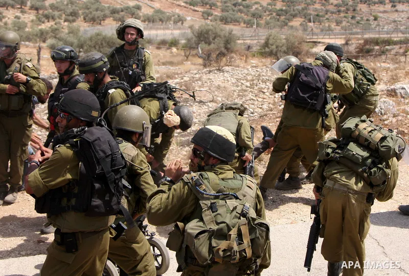 Protesters scuffle with Israeli soldiers during a protest against Israel's separation barrier in the West Bank village of Bilin near Ramallah, Friday, July 30, 2010. Photo by Wagdi Eshtayah