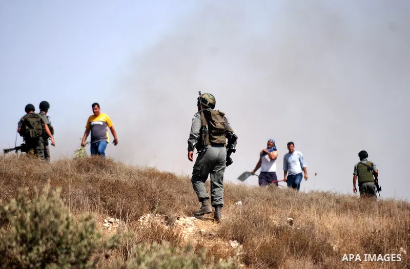 Palestinian men work to quell a fire started by Israeli settlers on the outskirts of Burin village, near the Jewish West Bank settlement of Yitzhar, near Nablus, Friday July 30, 2010. Photo by Wagdi Eshtayah