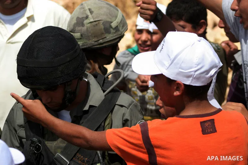 Israeli soldier scuffles with a Palestinian boy during a demonstration against Israel's controversial separation barrier in the village of Beit Omar near Jewish settlement of Karmi zur near the West Bank city of Hebron,...