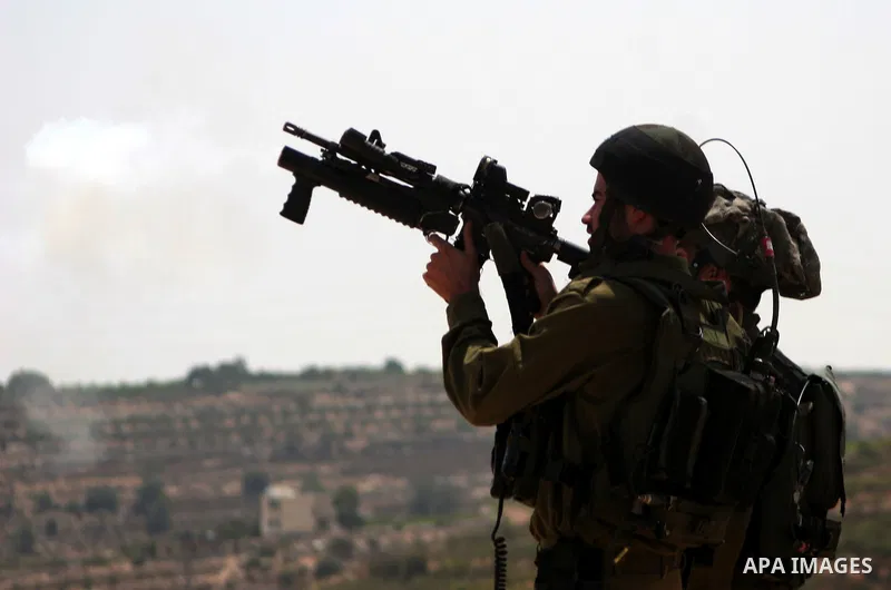 Israeli soldiers fire tear gas canisters at the Palestinian and foreign protesters during a demonstration against Israel's controversial separation barrier in the village of Beit Omar near Jewish settlement of Karmi zur...