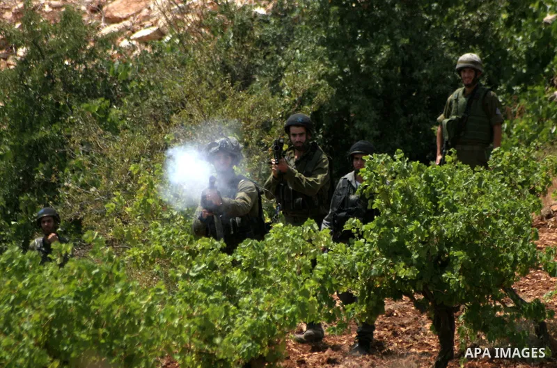 Israeli soldiers fire tear gas canisters at the Palestinian and foreign protesters during a demonstration against Israel's controversial separation barrier in the village of Beit Omar near Jewish settlement of Karmi zur...