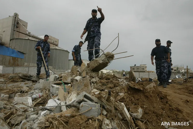 Members of Hamas security forces inspect a destroyed security site after Israeli air raid in al-Buriej refugee camp, central Gaza Strip, July 31, 2010. One Palestinian was found killed several hours after Israeli jet fig...