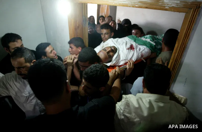 Palestinians carry the body of Issa Batran, a Hamas military commander and rocket maker, during his funeral in al-Buraij camp in the central Gaza Strip July 31, 2010. An Israeli air strike killed Batran in the Gaza Strip...