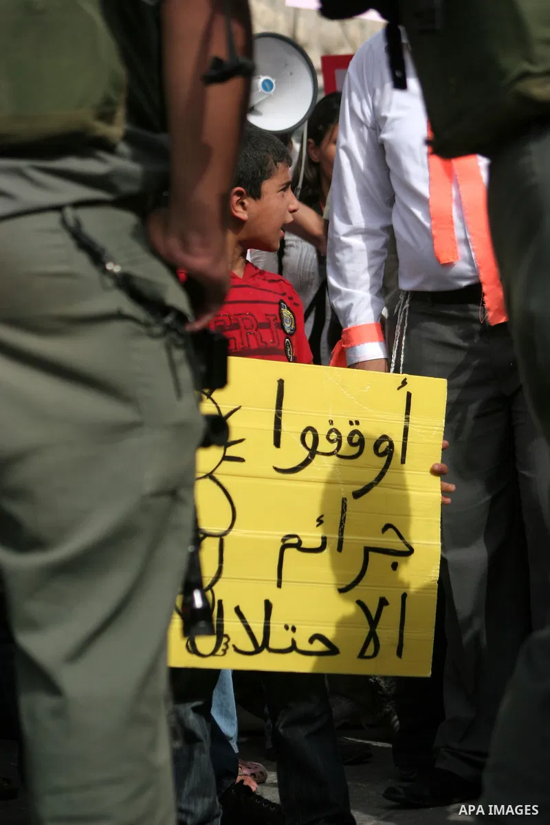 Palestinian and foreign activists take part in a weekly protest against the closing of Al-Shuhada Street in the West Bank old city of Hebron on July 31,2010. Palestinians, Israelis and International peace activists prote...