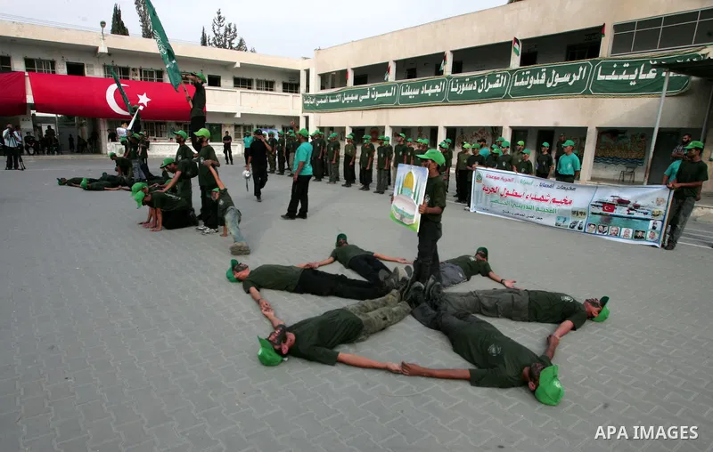 Palestinian boys perform exercises during a summer camp run by Hamas in the southern Gaza Strip town of Rafah on July 31,2010. In Gaza, summer camps aren't just about swimming, crafts and volleyball. They're about captur...