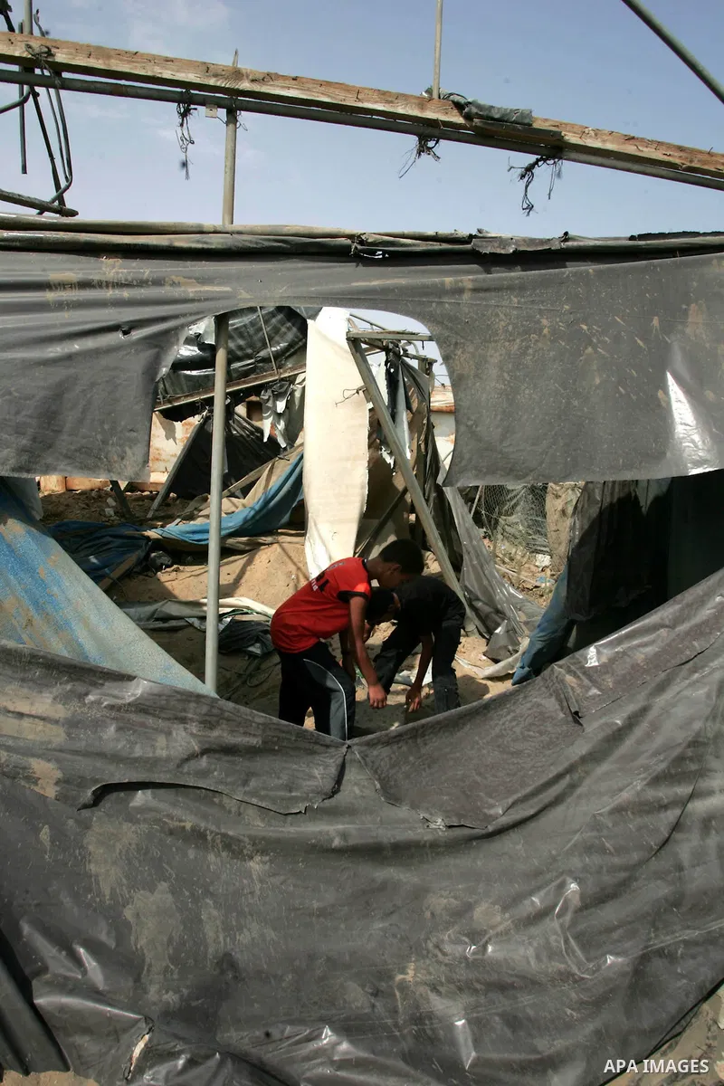 Palestinian children play at one of two smuggling tunnels damaged in two pre-dawn Israeli air strikes in Rafah town along the border with Egypt in the southern Gaza Strip on August 01, 2010, in which one person was injur...