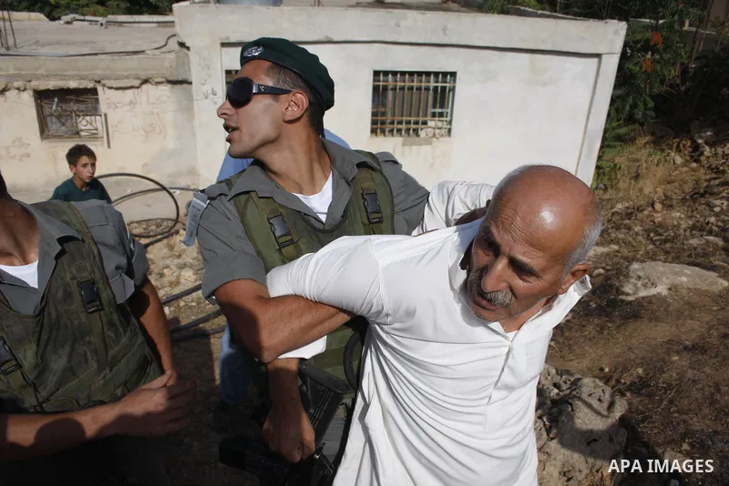 Israeli border policemen arrest Palestinian man during scuffles in the West Bank city of Hebron on August 2, 2010 after Israeli authorities destroyed the irrigation system in the Jaber family's land. Photo by Mamoun Wazw...