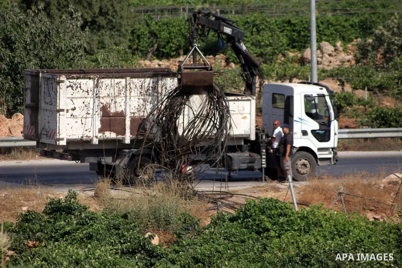 Israelis working with their army remove irrigation pipes from Palestinian agriculture land in the West Bank city of Hebron on August 2, 2010. Photo by Mamoun Wazwaz