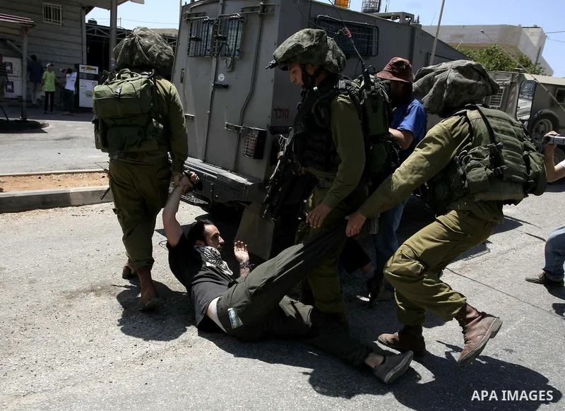 Israeli soldiers detain a demonstrator during a protest in the West Bank village of Nabi Saleh, on 06 August 2010. Residents of the village protest weekly against the neighbouring Jewish settlement of Halamish and the la...