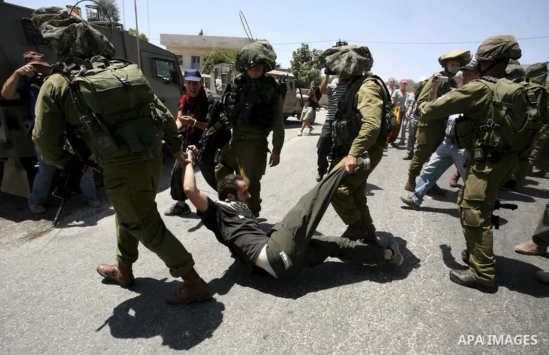 Israeli soldiers detain a demonstrator during a protest in the West Bank village of Nabi Saleh, on 06 August 2010. Residents of the village protest weekly against the neighbouring Jewish settlement of Halamish and the la...