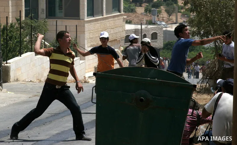 Palestinian boys use slingshots to throw stones at Israeli soldiers during a demonstration against Israeli settlements, in the West Bank village of Beit Omar, near Hebron, Saturday, on August 7, 2010.. Photo by Mamoun Wa...