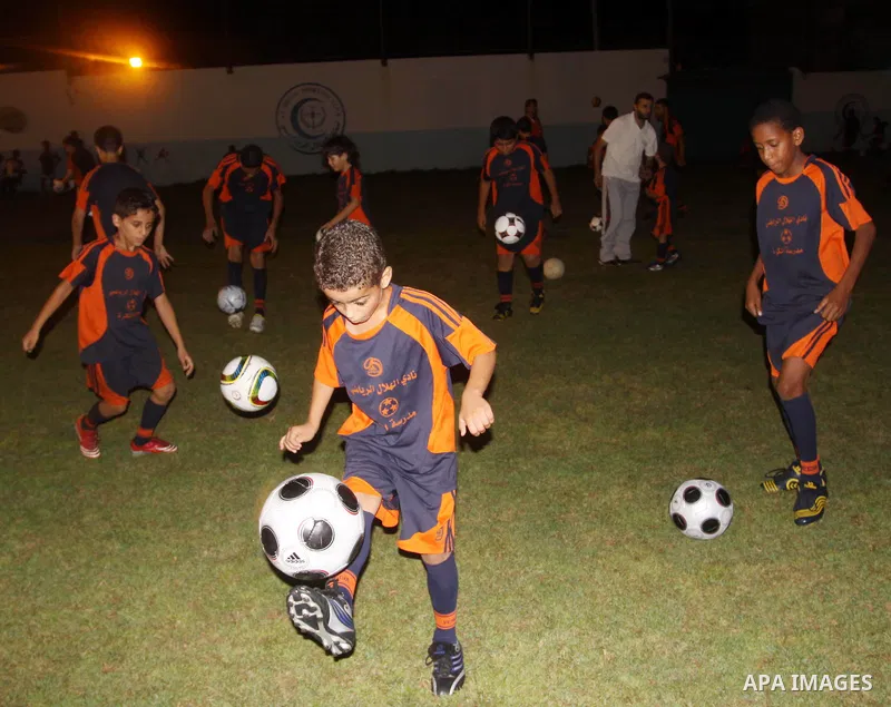 Palestinian children participate in the opening ceremony of the eighth season for football school at Al-Helal (Crescent) club in Gaza city on August 6,2010. Palestinian Children play football to practice their skills and...