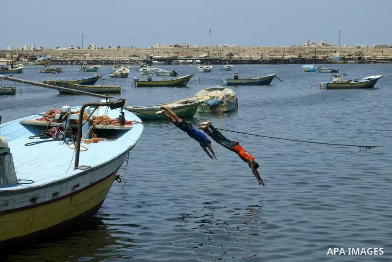 Palestinian boys enjoy swimming at the port of Gaza city on the sixth day of the holy month of Ramadan on August 16,2010. Photo by Ashraf Amra
