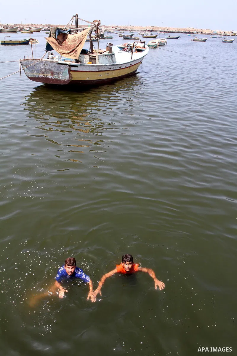 Palestinian boys enjoy swimming at the port of Gaza city on the sixth day of the holy month of Ramadan on August 16,2010. Photo by Ashraf Amra