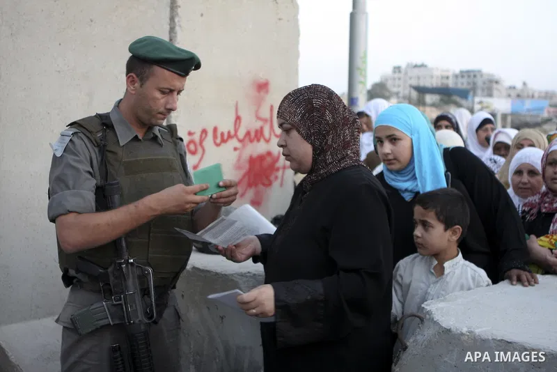 Palestinian women wait to cross the Kalandia checkpoint between the West Bank city of Ramallah and Jerusalem, manned by Israeli border police officers, to attend prayers at the Al Aqsa Mosque on the second Friday of the...