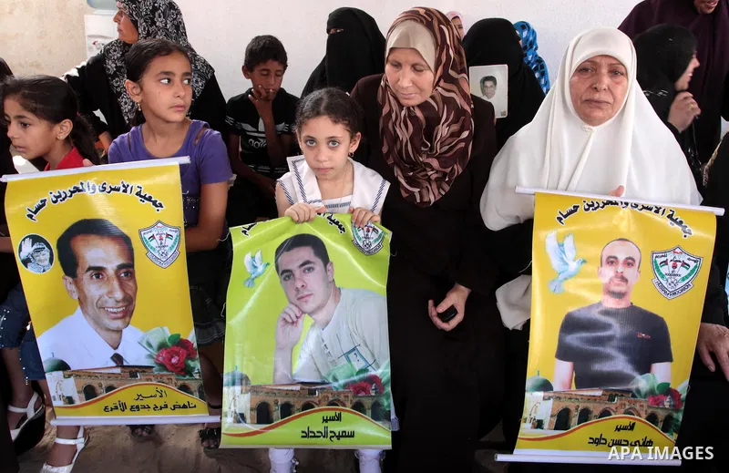 Palestinian women and children hold pictures of jailed relatives during a protest calling for the release of Palestinian prisoners from Israeli jails at the Red Cross office in Gaza City on August 23,2010. Photo by Moham...