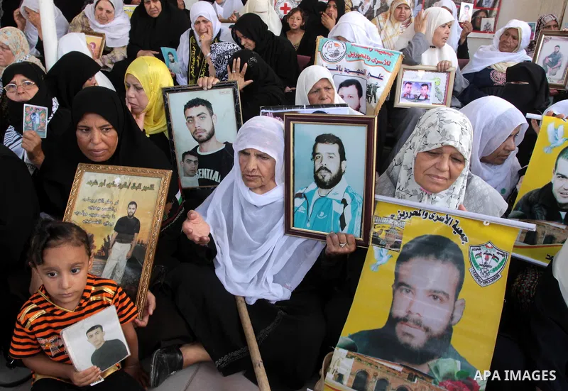Palestinian women and children hold pictures of jailed relatives during a protest calling for the release of Palestinian prisoners from Israeli jails at the Red Cross office in Gaza City on August 23,2010. Photo by Moham...