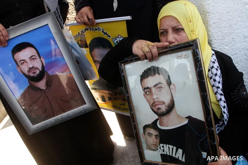 Palestinian women and children hold pictures of jailed relatives during a protest calling for the release of Palestinian prisoners from Israeli jails at the Red Cross office in Gaza City on August 23,2010. Photo by Ashra...