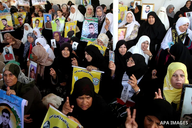 Palestinian women and children hold pictures of jailed relatives during a protest calling for the release of Palestinian prisoners from Israeli jails at the Red Cross office in Gaza City on August 23,2010. Photo by Ashra...