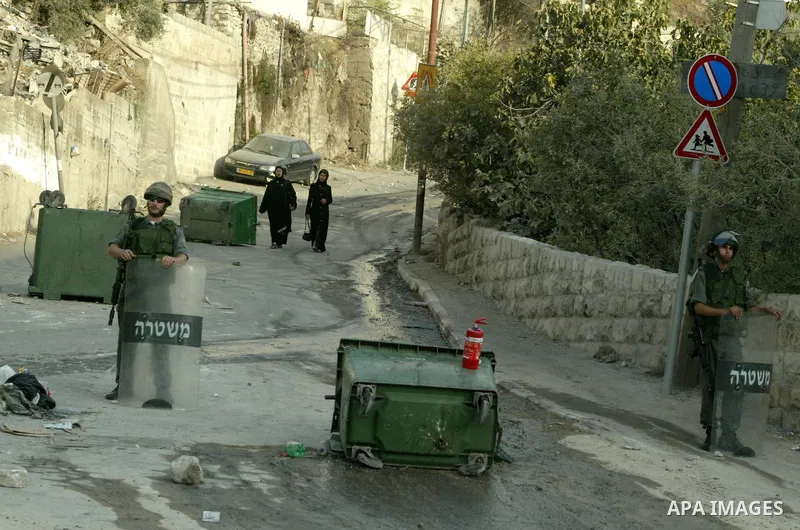 Israeli border policemen walk next to burned cars during clashes in the neighborhood of Silwan in east Jerusalem, Thursday Aug. 26, 2010. According to Palestinian witness riots broke out after masked Jewish men tried to...