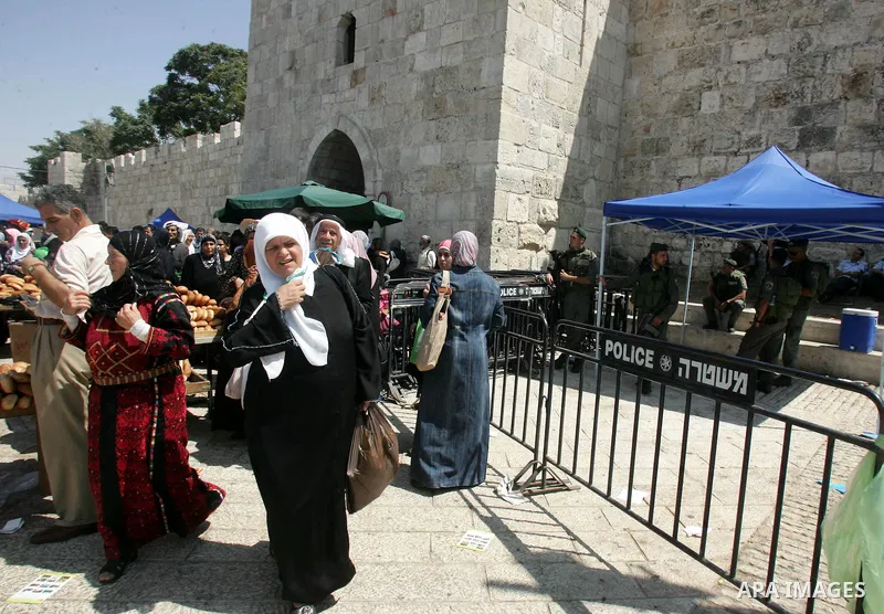 Palestinian worshippers walk past Israeli soldiers outside the Dome of the Rock, in the Al-Aqsa mosque compound in Jerusalem, during the third Friday noon prayer of the holy fasting month of Ramadan on August 27, 2010. P...