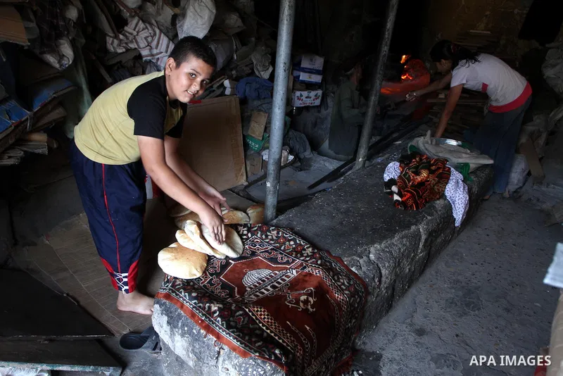 A Palestinian boy prepares loaves of bread for the baker at his traditional bakery in Gaza City on August 29,2010 . Photo by Ashraf Amra
