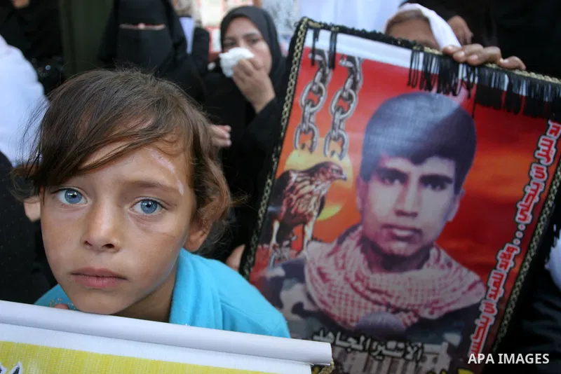 Palestinian women and children hold pictures of jailed relatives during a protest calling for the release of Palestinian prisoners from Israeli jails at the Red Cross office in Gaza City on August 30,2010. Photo by Moham...