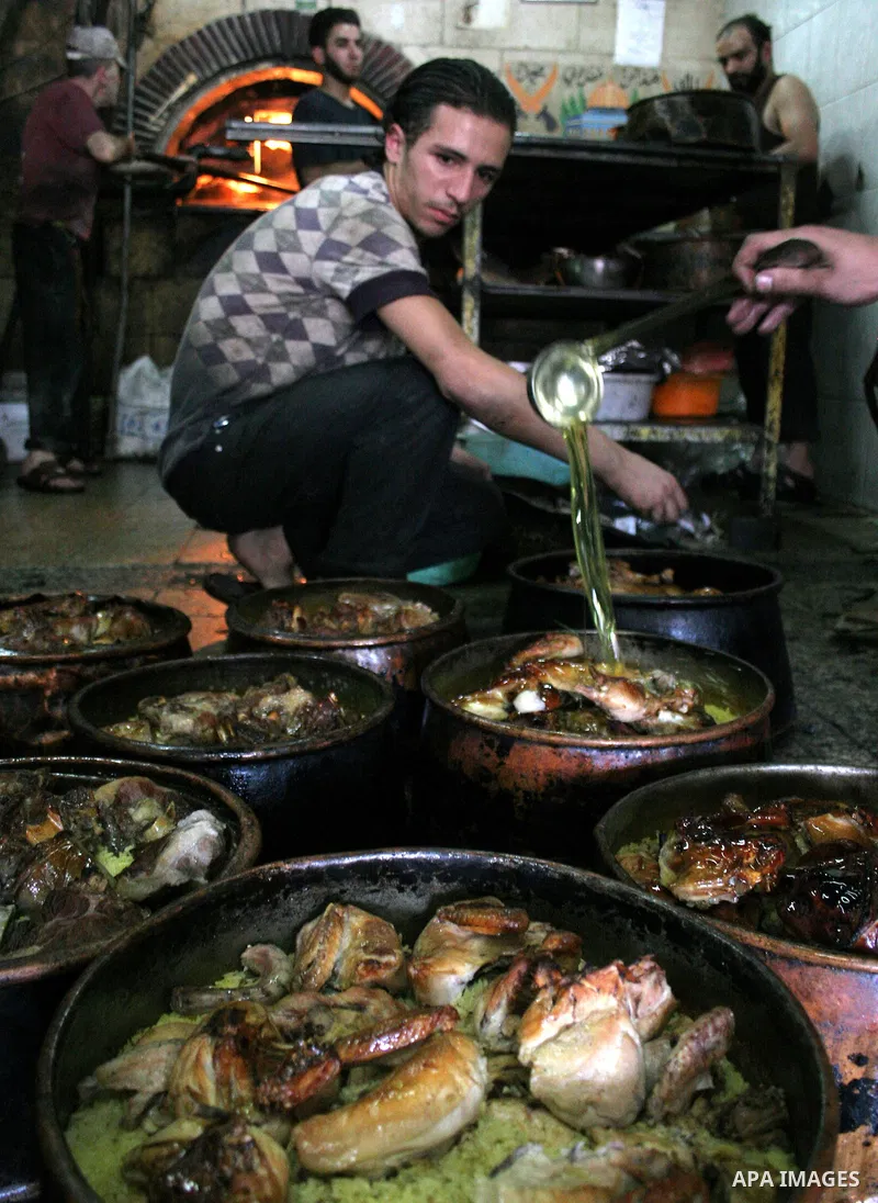 Palestinian bakers prepare jars full of rice and meat 'Qedrah" in a traditional stove in the West Bank city of Hebron on August 30, 2010 during the holy fasting month of Ramadan, when observant Muslims abstain from eatin...