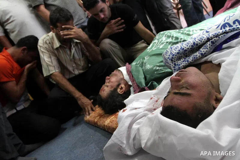 Palestinian mourners stand by the bodies of Khalid al-Khatib (top), 35-years-old, and Suleiman al-Hatab, 22-years-old, during their funeral in the al-Bureij refugee camp in the centre Gaza strip, on September 5, 2010, fo...
