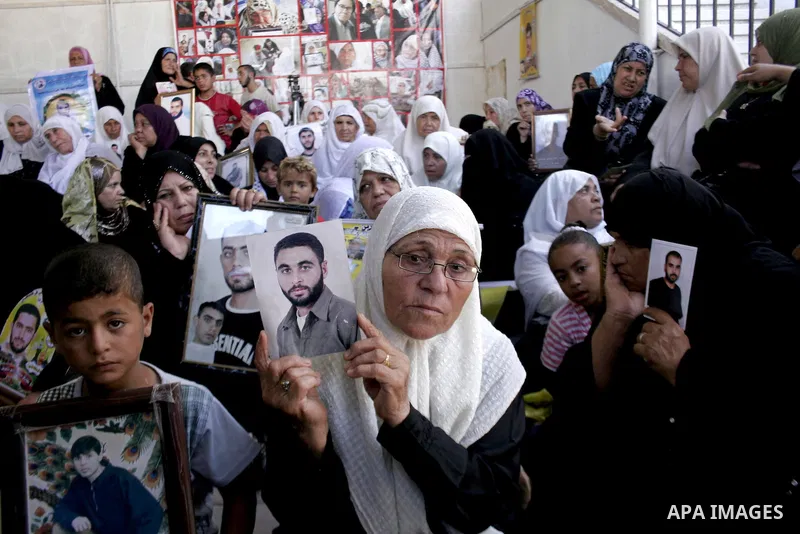 Palestinian women and children hold pictures of jailed relatives during a protest calling for the release of Palestinian prisoners from Israeli jails at the Red Cross office in Gaza City on Sept 6,2010 . Photo by Yousef...