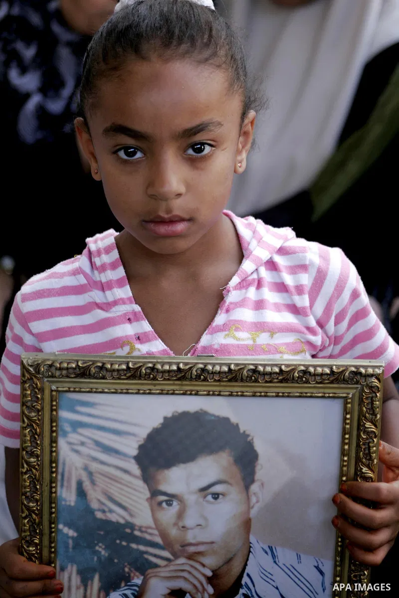 A Palestinian children holds pictures of jailed relatives during a protest calling for the release of Palestinian prisoners from Israeli jails at the Red Cross office in Gaza City on Sept 6,2010 . Photo by Yousef Deeb