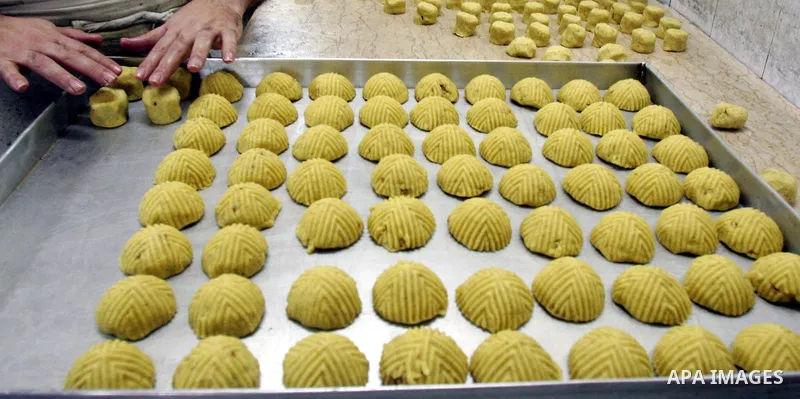 A Palestinian man prepares at a bakery date-filled mini cakes traditional for the Eid al-Fitr, a three-day holiday that marks the end of the fasting month of Ramadan, in Jerusalem's Old City on September 8, 2010. Photo b...