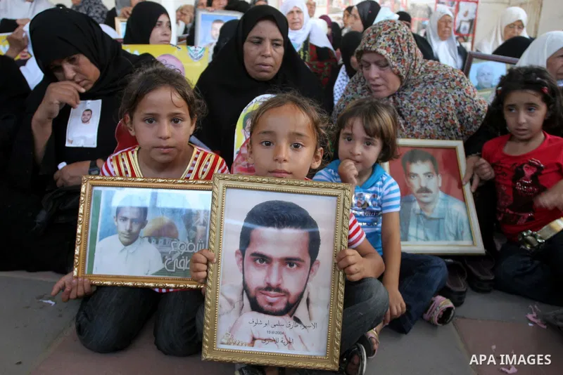 Palestinian women and children hold pictures of jailed relatives during a protest calling for the release of Palestinian prisoners from Israeli jails at the Red Cross office in Gaza City on Sept 13,2010 . Photo by Mohamm...