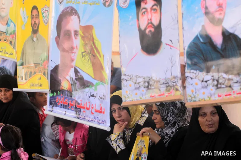 Palestinian women and children hold pictures of jailed relatives during a protest calling for the release of Palestinian prisoners from Israeli jails at the Red Cross office in Gaza City on Sept 13,2010 . Photo by Mohamm...