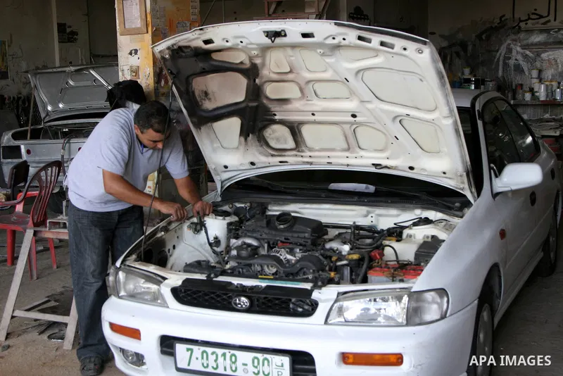 Palestinian professional inspect the car in a garage that burned down byJewish settlers in the West Bank village Ourif near the city of Nablus on Sept. 13, 2010 . Photo by Wagdi Eshtayah