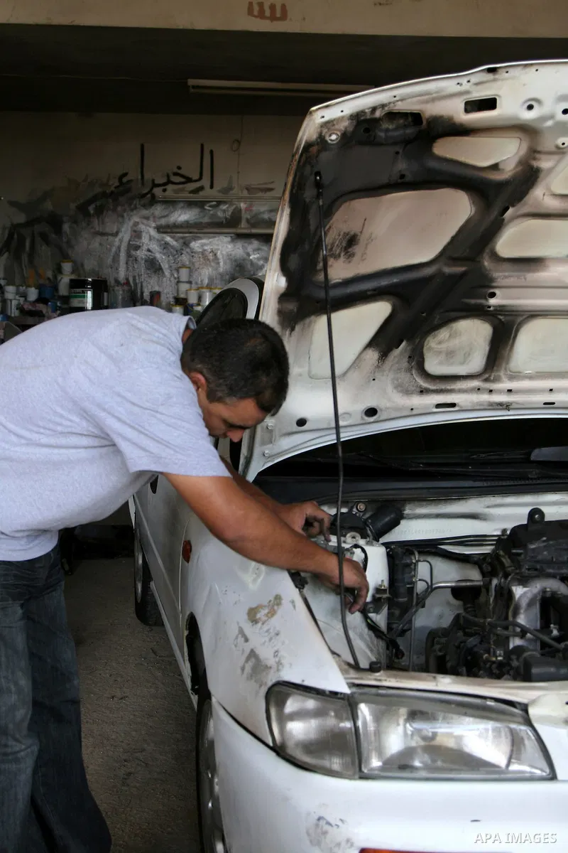 Palestinian professional inspect the car in a garage that burned down by Jewish settlers in the West Bank village Ourif near the city of Nablus on Sept. 13, 2010 . Photo by Wagdi Eshtayah