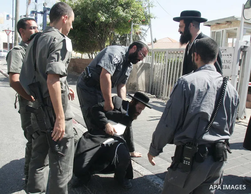 An ultra-Orthodox Jew is grabbed by an Israeli Border policeman during a protest in the coastal town of Jaffa, just south of Tel Aviv, on Sept. 14, 2010 over the town's decision to remove ancient graves found during the...