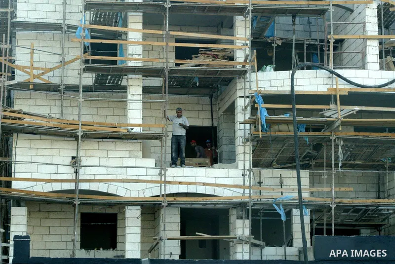 Palestinian laborers work on a construction site in the Jewish settlement of Har Homa, on the outskirts of Jerusalem on September 16, 2010. US Secretary of State Hillary Rodham Clinton arrived to the Palestinian Authorit...