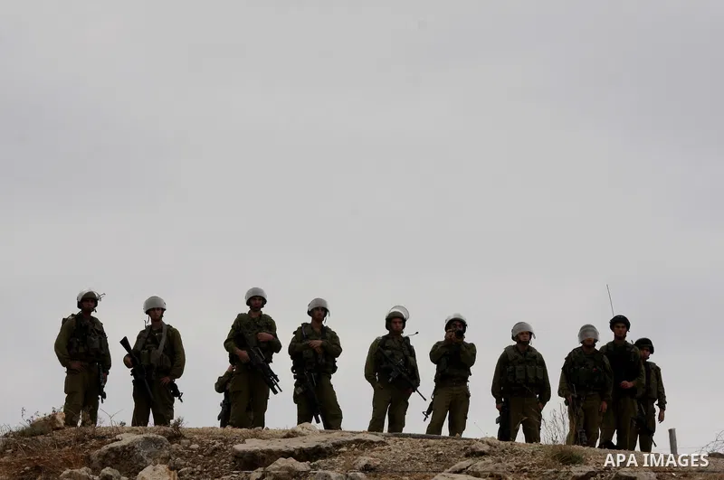 Israeli soldiers stands guard during a proteste by Palestinian and foreign activists against Israel's separation barrier in the West Bank village of Bilin near Ramallah on September 17, 2010. Photo by Eyad Jadallah